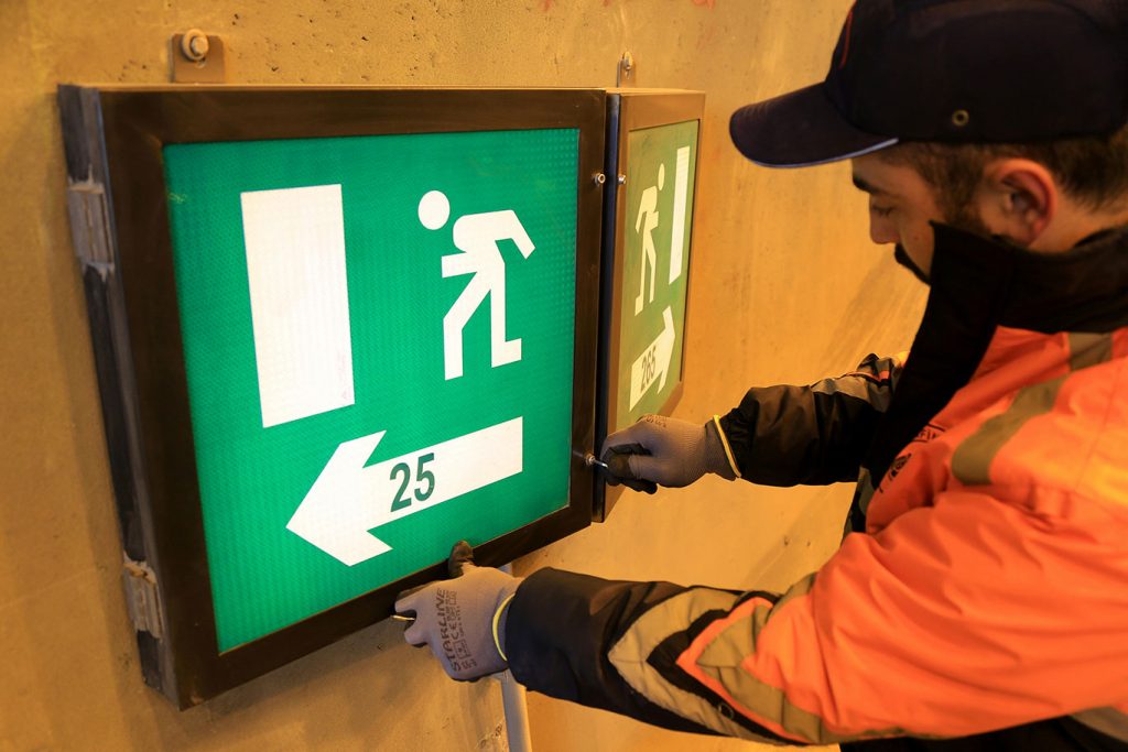Man maintaining a building's safety lighting